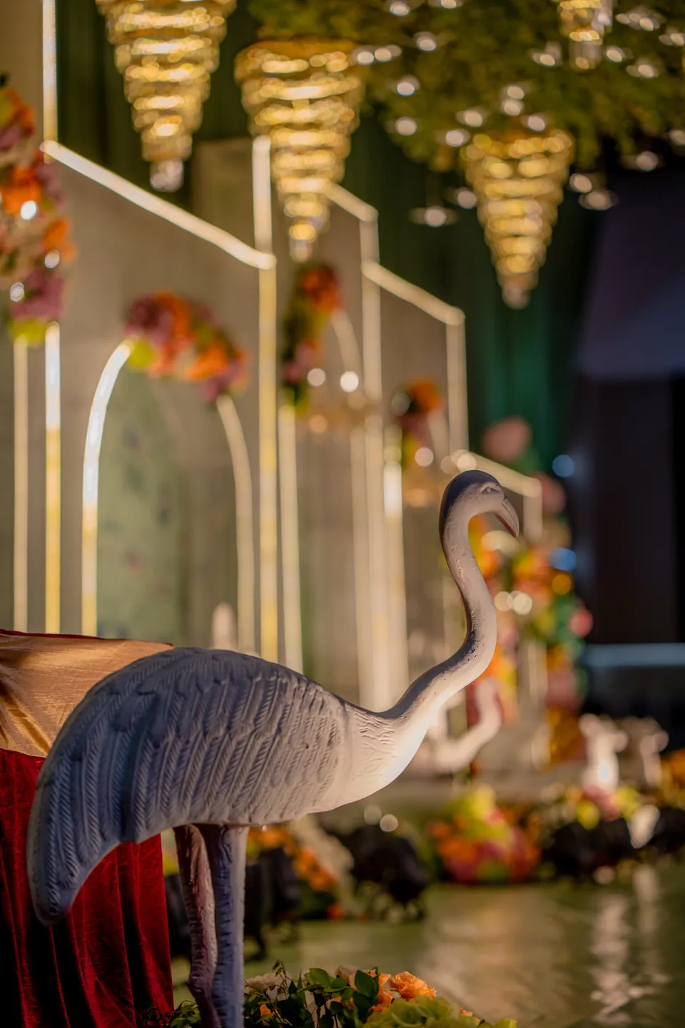 Swan sculpture and warm chandelier light in a decorated hall
